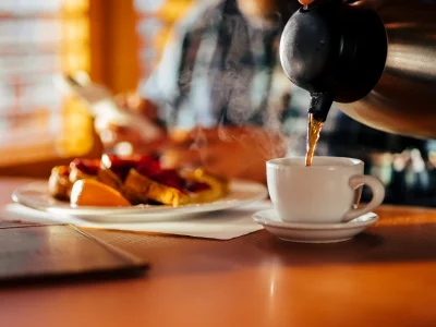 Mann sitter på en diner og spiser vafler og drikker kaffe
