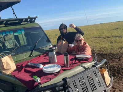 To personer spiser frokost i safaribilen